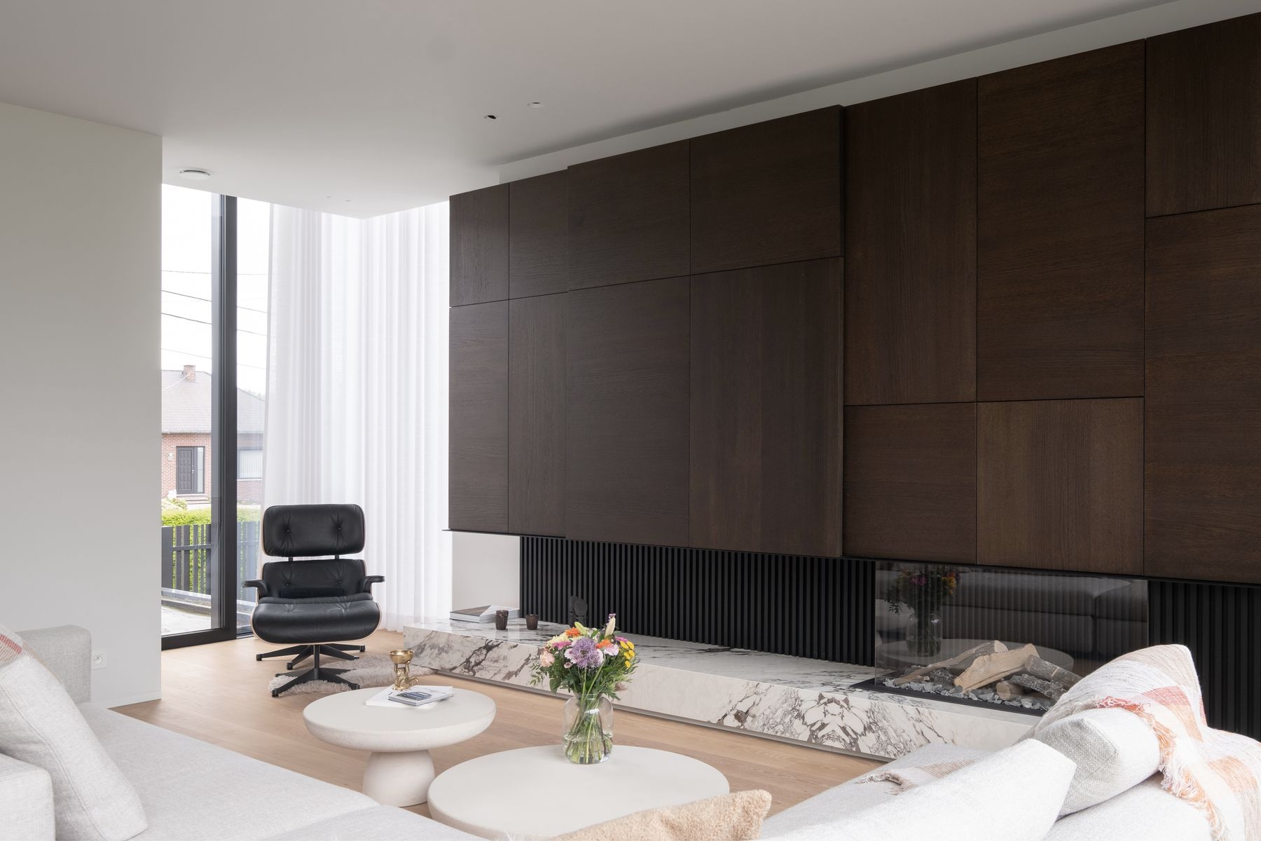 Leefruimte met donkere houten wand en haard