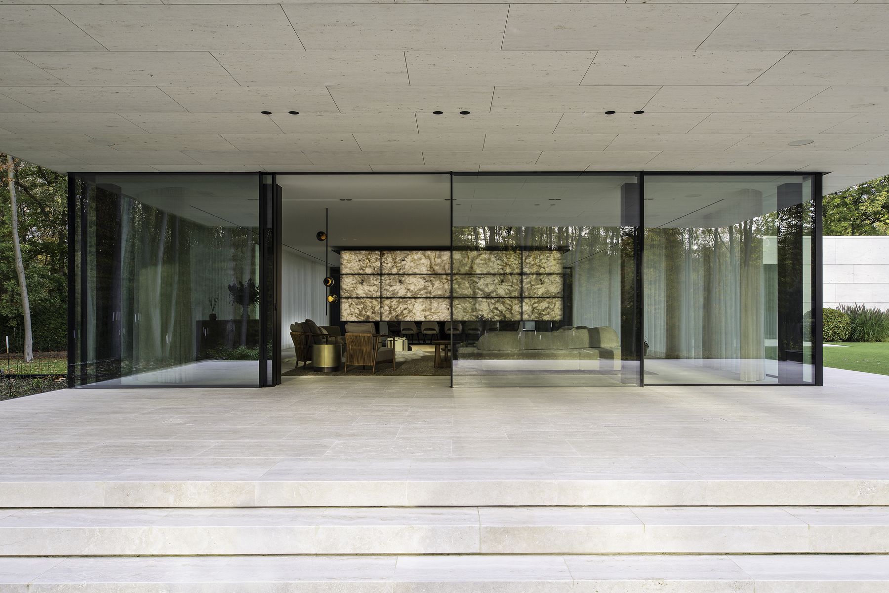 Glazen paviljoen met verlichte onyxwand